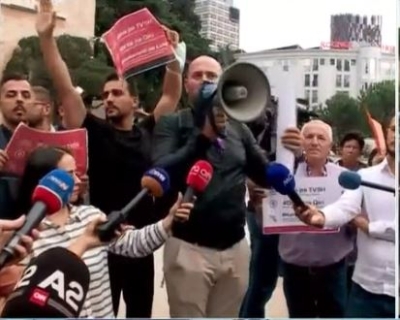 Aktori i humorit në protestën para Kryeministrisë/ Florian Binaj shpalos pankartën: Nuk hamë të gjithë te Nusreti! Ja mesazhi i tij